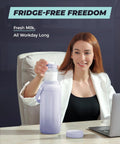 Keep Your Nursing Stash Chill Without Any Stress Using This Leakproof Breast Milk Travel Chiller That Attaches Straight To Pumps And Keeps Fresh Milk Cold All Day Long, modeled by a woman at a desk.