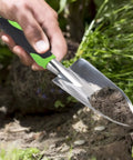 Person using Heavy Duty Cast Aluminum Garden Hand Shovel And Trowel For Planting Transplanting Weeding And Digging Soil With Soft Rubberized Non Slip Grip Handle 11.8 Inch Green Workhorse Tool for gardening