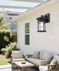 Black Outdoor Wall Light Fixture Seeded Glass Modern Farmhouse Exterior Lantern with E26 Base on a patio wall