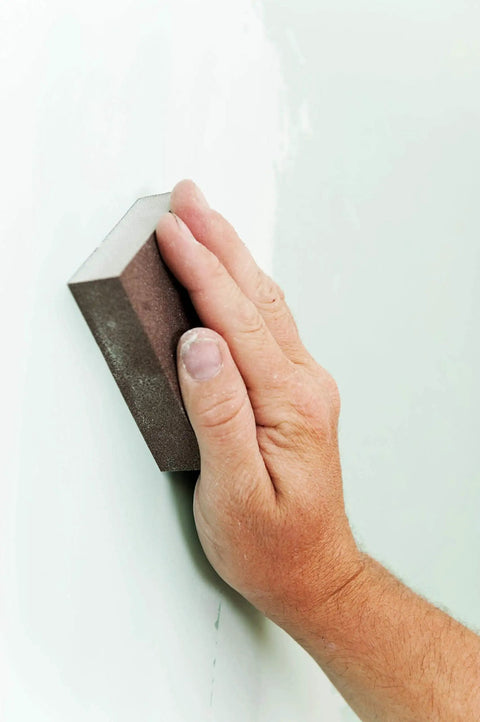 Fine Grit Sanding Sponges 6-Pack For Smooth Finishes On Wood, Metal, And Plastic being used on a wall