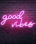 Good Vibes Pink Neon Sign With Dimmable USB Power Ultra Bright LED Wall Light For Bedroom And Home Bar Retro 70s Vibe Mood Decor 16.1 by 8.3 Inches Neon Light For Fun Atmosphere against brick wall