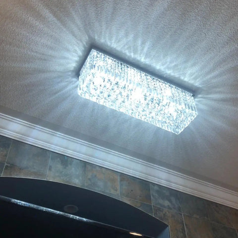Lit Modern Crystal Rectangle Chandelier Lighting With Raindrop Crystals, chrome flush mount illuminating a ceiling.