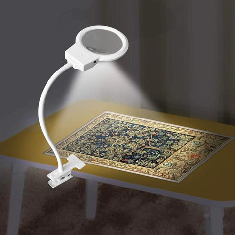 LED Magnifying Lamp For Diamond Painting Tools With 4X And 6X Magnifier illuminating a cross stitch project on a table.