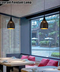 Industrial Wrought Iron Pendant Light Adjustable Single Head E27 Chandelier for Kitchen Island in a modern restaurant setting.