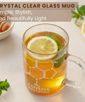 Caffeine Molecule Beaker Mug With Handle, Clear Glass Measuring Cup Coffee Cup filled with lemon tea and mint leaves