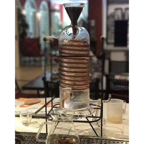 Next Level Glass Cold Brew Coffee Tower Featuring An Adjustable Speed Dripper And Clever Spiral Cooling Tube For Killer Iced Coffee Or Tea Effortlessly, 250ml, borosilicate glass, on display.