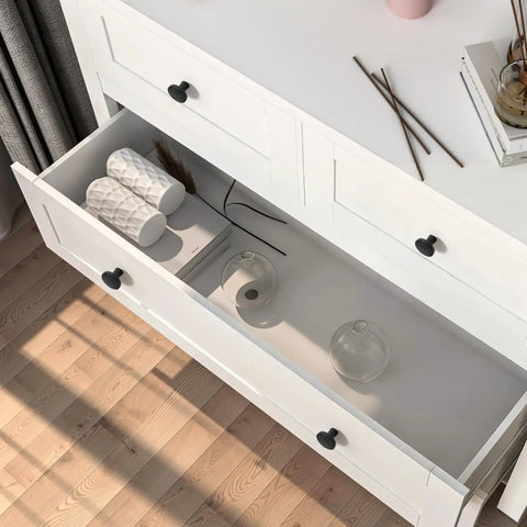Overhead view of open white dresser with Matte Black Cabinet Knobs Set Ten Pack One And A Quarter Inch Round Solid Zinc Alloy Drawer Pulls For Kitchen Cabinets Bathrooms Vanities Dressers Cupboards Hardware.