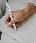 Person writing with retractable gel ink pen, smooth quick dry writing, leak free and smudge resistant office and school supplies.