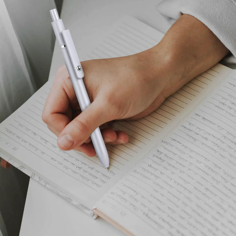 Person writing with retractable gel ink pen, smooth quick dry writing, leak free and smudge resistant office and school supplies.