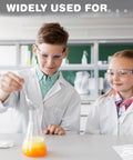 Kids wearing Kid Friendly 24 Pack Safety Glasses With Clear Lenses, Scratch Resistant, in a science lab with beaker