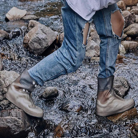 Person hiking through stream wearing Waterproof Rain Boot Covers For Men And Women, Reusable Foldable Overshoes, ankle high grey.