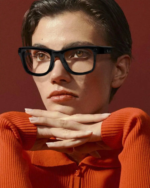 Person wearing black Wayfarer-style glasses looking thoughtful