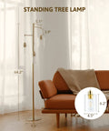 Dope Gold 64 Inch Tree Floor Lamp With Three Branches And Glass Shades next to a brown sofa in a living room setting.