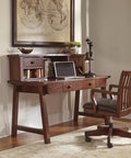 Home office setup with wooden desk and chair next to a window and a map decor.