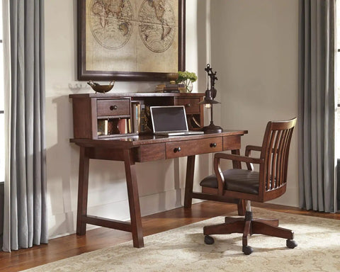 Home office setup with wooden desk and chair next to a window and a map decor.