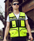 Heavy Duty High Visibility Safety Vest Featuring Breathable Mesh Lining Multiple Storage Pockets And Bright Fluorescent Yellow Fabric For Construction Crew Daily Grind And Rugged Shop Tested Workwear worn by man outdoors.