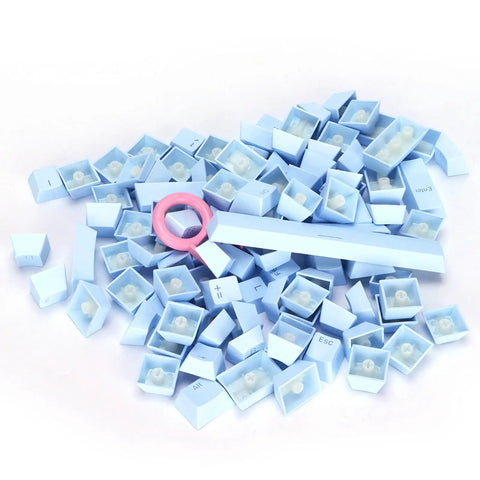 Premium PBT Keycaps With Dope Colorway And Ergonomic Arc Fit Smooth Typing Feel Hella Durable Oil Resistant Texture Perfect 108 Keys Layout For Gaming Rigs And Productivity Workstations In Light Blue Finish scattered with a keycap puller.