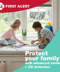 Two children playing near a window with First Alert logo, highlighting home safety with smoke and CO detection system.