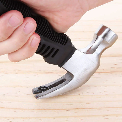 Close-up of a person holding an 8 Oz Stubby Claw Hammer Mini 6 Inch 4 Pack With Soft Rubber Grip Ergonomic Handle for home repair.