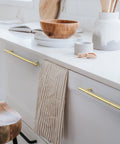 Solid Brass Kitchen Cabinet Pulls Set of 6 in Polished Gold with Hammered T-Bar Handles installed on white cabinet