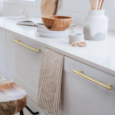 Solid Brass Kitchen Cabinet Pulls Set of 6 in Polished Gold with Hammered T-Bar Handles installed on white cabinet