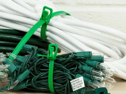 Heavy Duty Reusable Cable Ties With No Sweat Quick Release Lever Rock Solid Wire Control 275 Pound Pull Strength securing green cables.