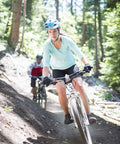 Cyclist on trail wearing helmet with mountain bike tire 26x1.75-2.125in, showcasing grippy tread for trail control and durability.