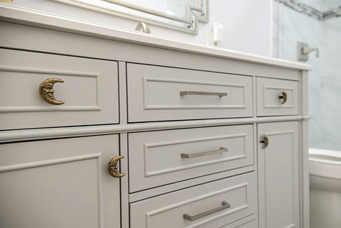 Bathroom cabinet with Set Of Six Gold Finish Cast Iron Crescent Moon Face Drawer Pulls For Celestial Decor installed.
