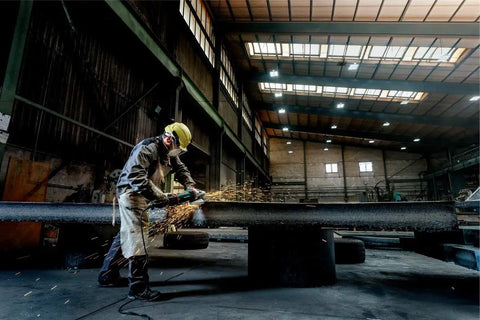 Worker using 9-Inch Angle Grinder With Lock-On Trigger, 6600 RPM, 15 Amp, W24-230 MVT for metalwork in industrial setting
