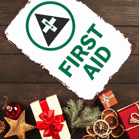 Funny Safety Sign 8x12 Inch Aluminum Wall Decor, first aid symbol, placed near holiday decorations on wooden table.
