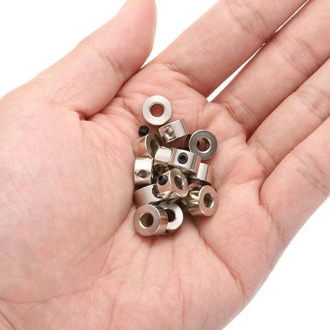 Hand holding 15 Piece Set Screw Shaft Collars 4.05mm Bore 9mm OD 5mm Width Nickel Plated Carbon Steel Drill Stop Collars