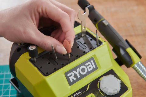 Hand inserting a sanding drum into the Badass 18 Volt Cordless Mini Rotary Tool with 35 Premium Accessories.