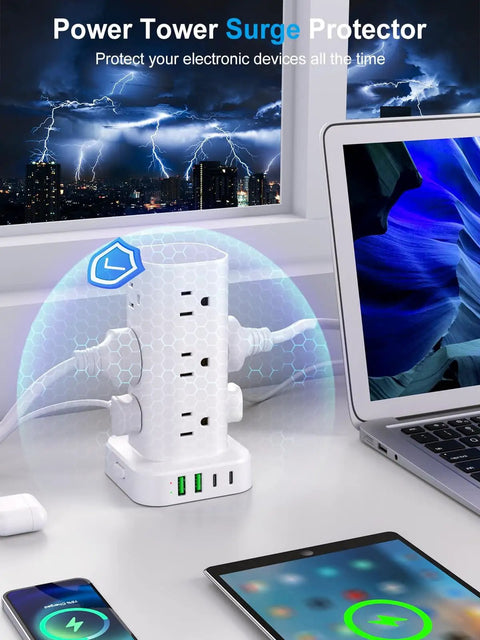 Power Strip Tower With 12 AC Outlets And 4 USB Ports 2 USB C 2 USB A For Home Office Dorm Room Flat Plug Surge Protector 6ft Cord Charging Station 16 In 1 White on a desk near a laptop, charging multiple devices.