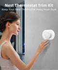 Woman adjusting Snow Color Nest Thermostat 2020 Wall Plate Cover And Trim Kit with Easy Install Modern Wall Plate Accessory.