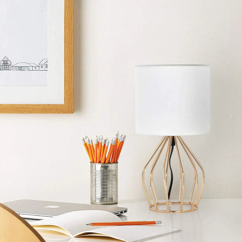 Gold Modern Farmhouse Table Lamps Set Of 2 With Hollowed Out Base And White Fabric Shade on a desk beside a pencil holder