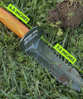 Prospector's Serrated Edge Digger Compact Shovel with 7.5in carbon steel blade and orange grip shown in grass.