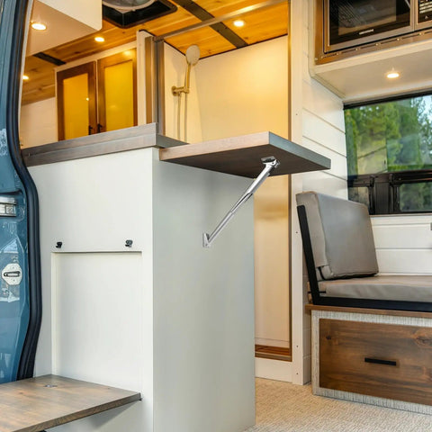 Heavy Weight Aluminum Alloy Telescopic Wall Mount Bracket With Quick Grip Auto Lock, supporting a foldable table in an RV.