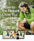 Man in green jacket checking phone with a digital video recorder display of porch delivery, highlighting home monitoring.