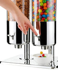 Level Up Your Kitchen Game With This Heavy Duty Dual Chute Cereal Dispenser showing a hand using the lever to dispense snacks.