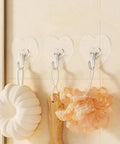 Heavy Duty Adhesive Wall Hooks With Slick Grip keep towels and loofahs organized in a bathroom with a transparent design.