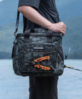 Person holding BaitSpace Tackle Bag With Four Tackle Boxes, Removable Bait Binder by a lake, showing heavy duty nylon build.