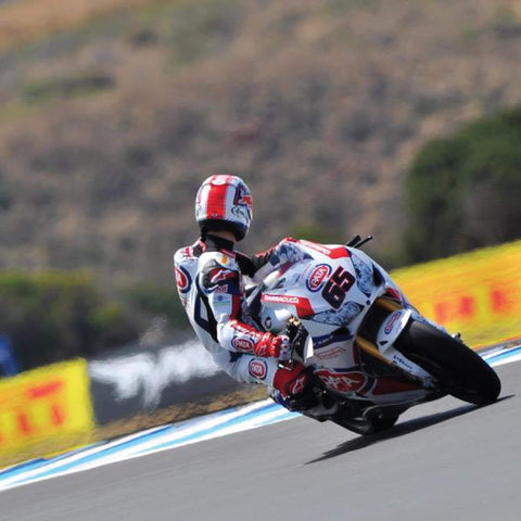 Motorcyclist leaning into a turn on a track, equipped with Pirelli Angel ST Front And Rear Sport Touring Motorcycle Tires.