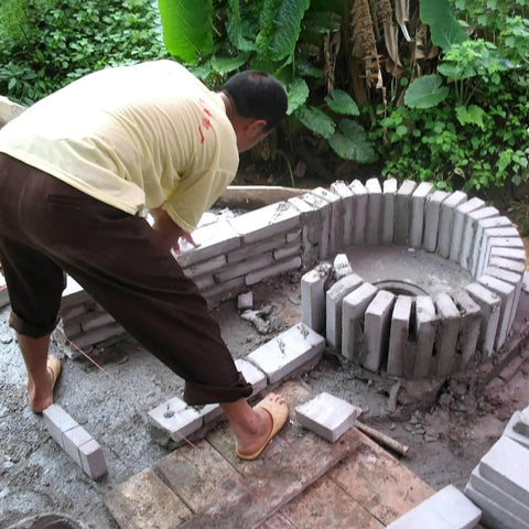 Man constructing a stone structure for Off Grid Ready Axial Flow Hydroelectric Generator 2000W 220V Single Phase Hydro Turbine installation.
