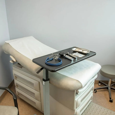 Heavy Duty Adjustable Overbed Table With Ball Bearing Casters, Versatile Rolling Bedside Desk For Hospital Couch Or Wheelchair, No Hassle Portable Laptop Stand For Home in a medical setting.