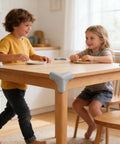 Children at table with Three-Sided Wrap Table Corner Protectors, No-Drill PVC Self-Adhesive Guards in Black installed