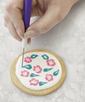 Close-up of cookie decorating using Top Shelf Cookie Decorating Tools Set Featuring Etching Wand Triple Comb And Flexible Silicone Scraper.