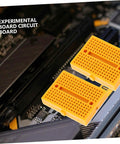 Plug And Play Solderless Breadboard Kit With Six Compact Yellow Protoboard Panels For Rapid Circuit Assembly and Hassle Free Electronics Crafting For Tech Students And Weekend Builders, shown on a circuit board.