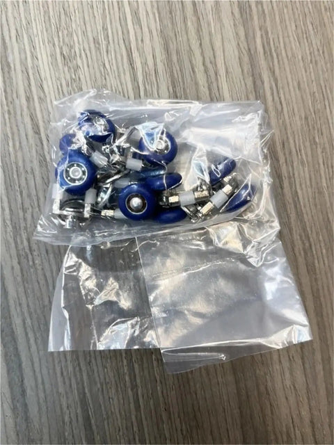 Heavy Duty Silent Curtain Track Gliders 20 Piece Pack with blue metal pulleys in a transparent bag on wooden surface.