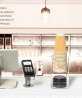 Two Tier Upright Cup And Condiment Organizer With Two Compartment Clear Acrylic Cup Dispenser on a coffee counter