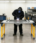 Welder using Heavy Duty Folding Welding Table With 1200 Lb Load Capacity And Adjustable Height Setup For Real Shop Projects Built Like A Tank Steel Work Bench Surface.